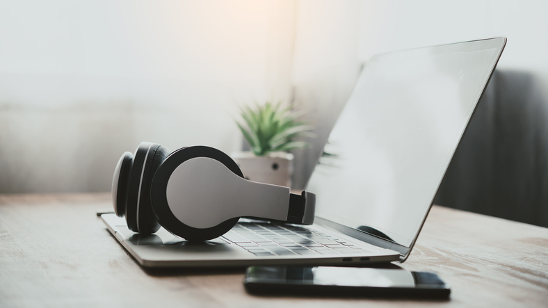 headphones are on a laptop, on the desk.  Concepts of music for relaxation